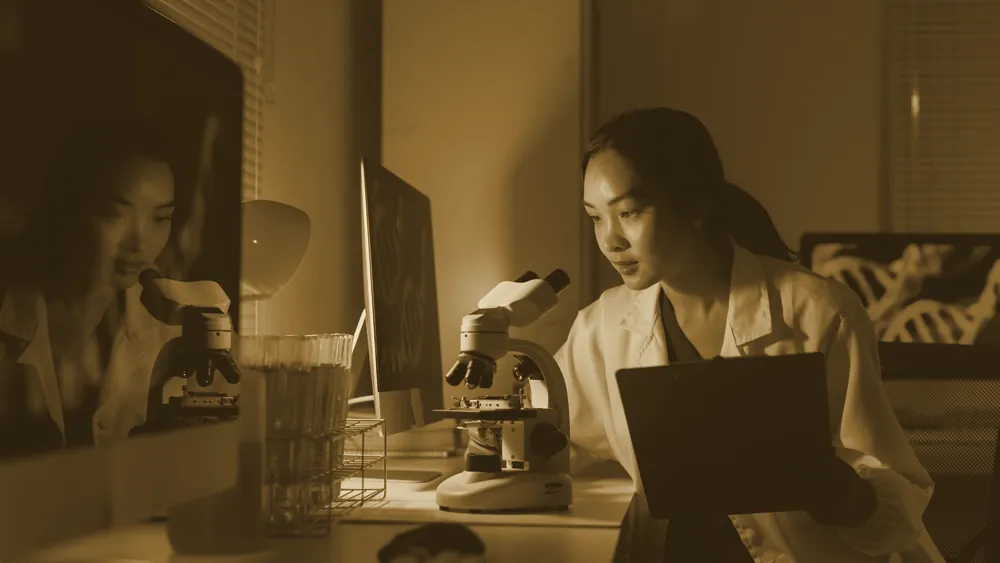 A scientist examining a sample under a microscope in a laboratory