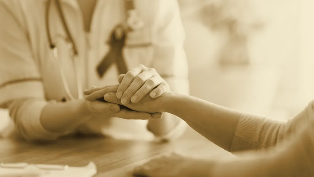 A doctor holding a purple cancer-awareness ribbon