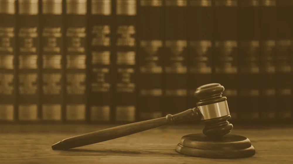 A gavel and law books on a wooden desk