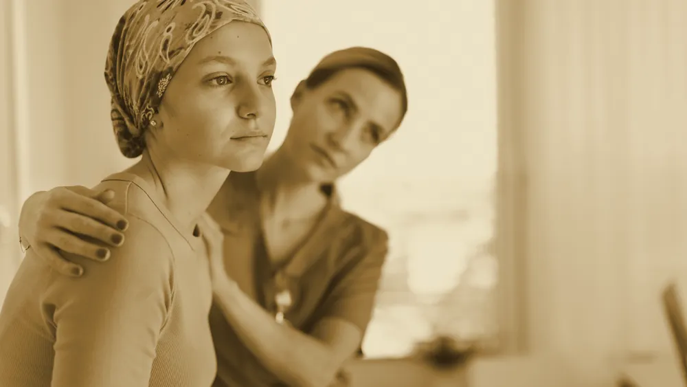 A caring nurse comforting a young woman in hospital
