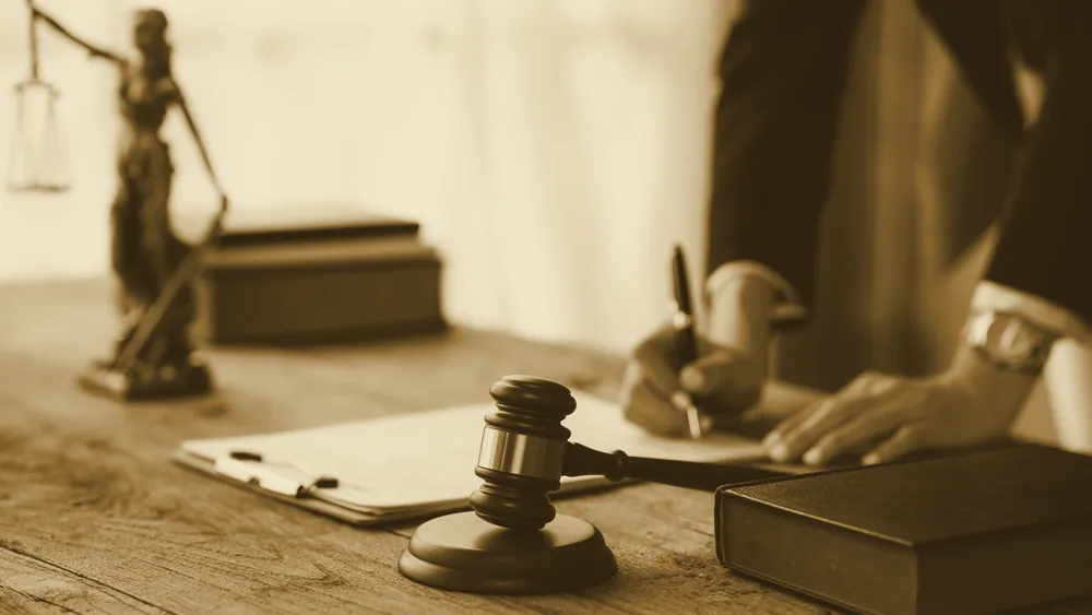 A legal professional working at a desk beside a gavel