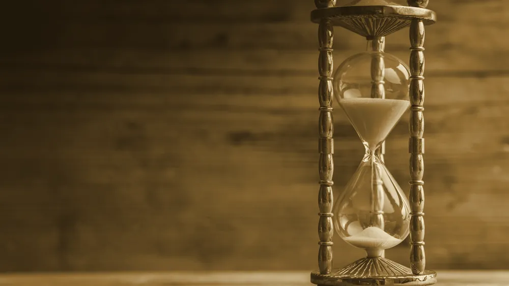 A vintage hourglass on a wooden surface