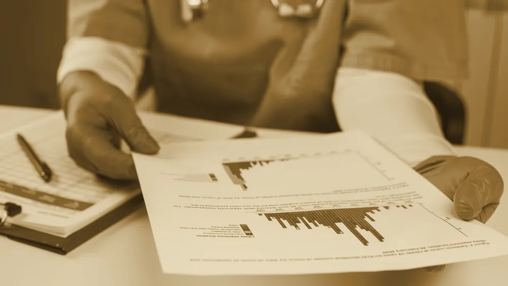 A healthcare professional analyzing a medical chart at a workstation