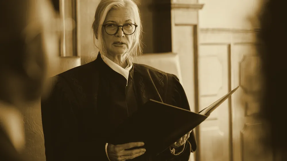 A judge holding a law book in a courtroom